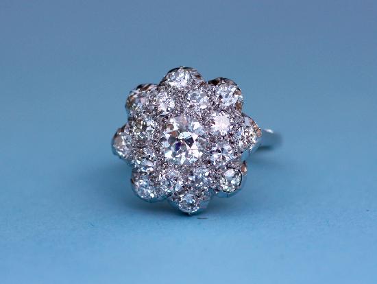 1930S DAISY CLUSTER DIAMOND ENGAGEMENT RING.