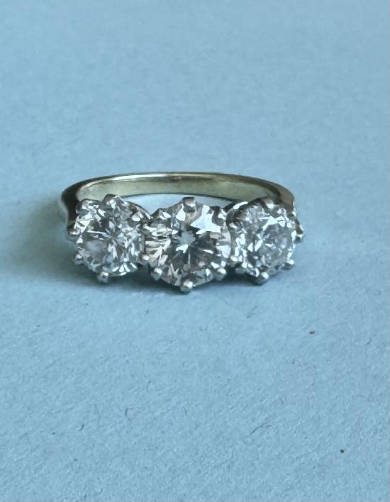 CHARMING THREE-STONE DIAMOND RING.